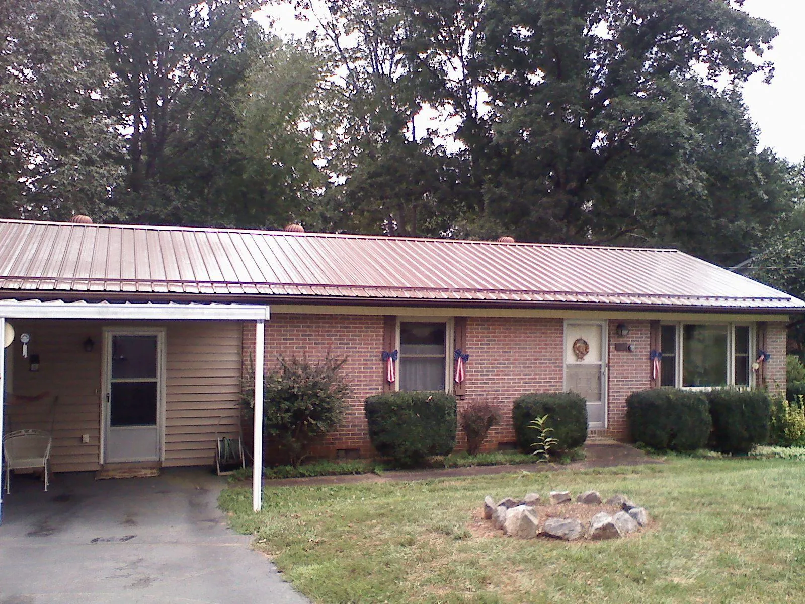 Bronze metal roof and carport on a brick ranch home — Roof Repair work by our crew in Ocean View